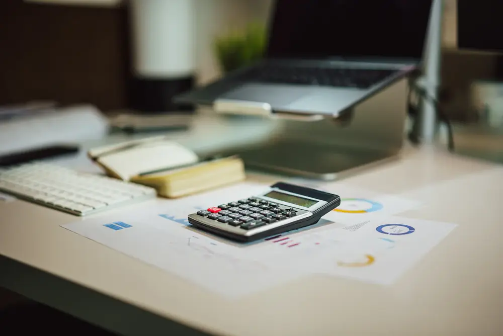 Calculadora y reportes sobre un escritorio